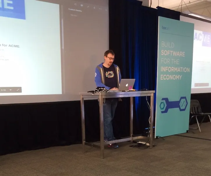 Ryan Lopopolo presenting from a laptop onstage at Box Dev beside a “Build software for the information economy” banner.
