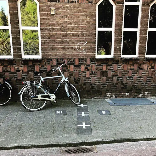Bicycle parked near border markings in Baarle where national boundaries pass through the street.